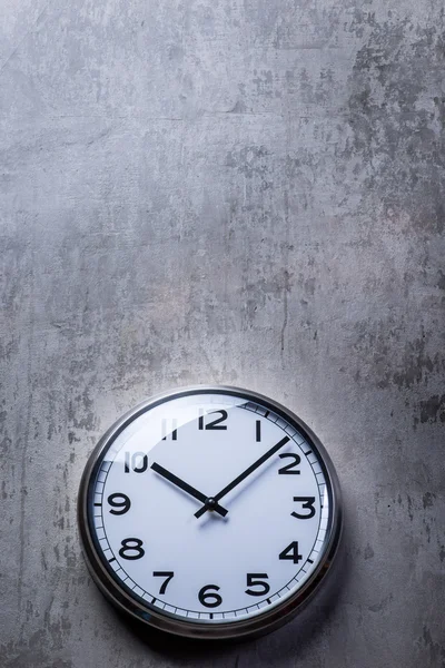 Round wall clock hanging on the grey concrete wall — Stock Photo, Image