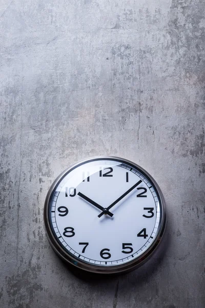 Gri beton duvara asılı yuvarlak duvar saati