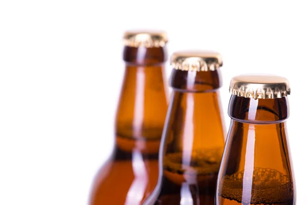 Tre bottiglie di birra ghiacciata isolate su bianco — Foto Stock