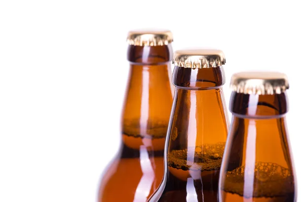 Tre bottiglie di birra ghiacciata isolate su bianco — Foto Stock