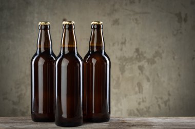 Taze demlenmiş bira şişeleri üst üste gri beton duvarı