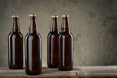 Taze demlenmiş bira şişeleri üst üste gri beton duvarı