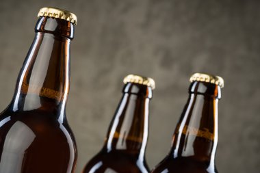 Taze demlenmiş bira şişeleri üst üste gri beton duvarı