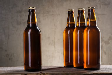 Taze demlenmiş bira şişeleri üst üste gri beton duvarı