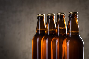 Taze demlenmiş bira şişeleri üst üste gri beton duvarı