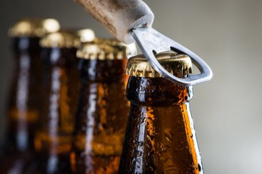 Brown ice cold beer bottles with old opener