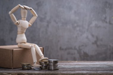 Paralar ile gri beton duvardan oturan ile küçük ahşap kukla