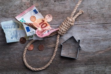 Hangman's noose evi, anahtarları ve kahverengi ahşap yüzey üzerinde para ile