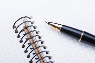Spiral defter ile izole beyaz arka plan üzerinde siyah topu kalem