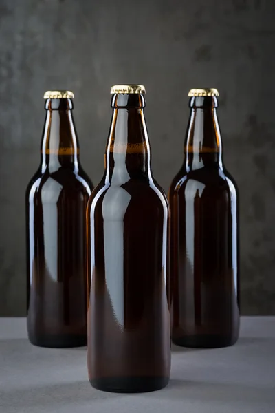 Taze demlenmiş bira şişeleri üst üste gri beton duvarı