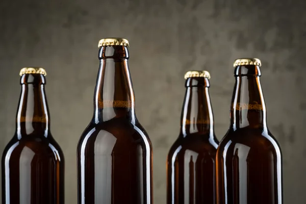 Frisch gebrühte Bierflaschen reihen sich über die graue Betonwand — Stockfoto