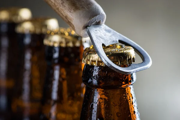 Botellas de cerveza fría de hielo marrón con abridor viejo —  Fotos de Stock