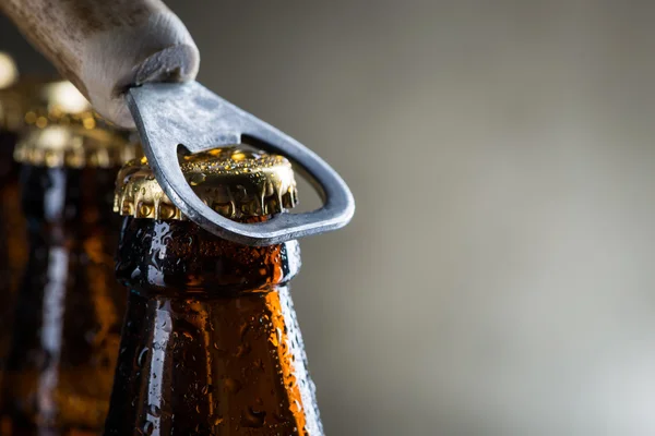 Kahverengi buz soğuk bira şişeleri ile eski açacağı