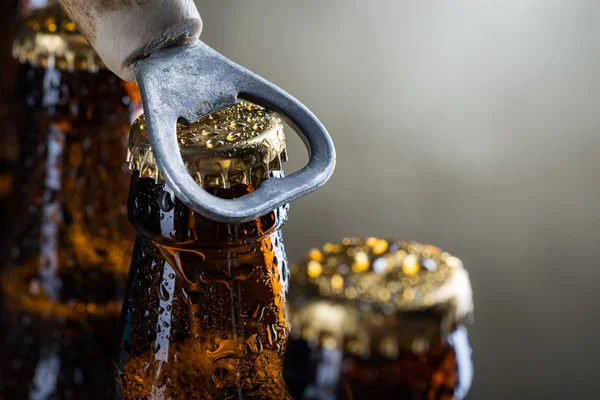 Bouteilles de bière glacée brunes avec vieil ouvre-bouteille — Photo