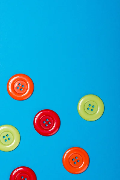 Una gran cantidad de botones de colores sobre un fondo azul — Foto de Stock