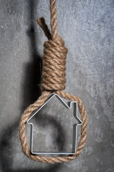 Small house framed with hangman's noose over the grey concrete wall — Stock Photo, Image