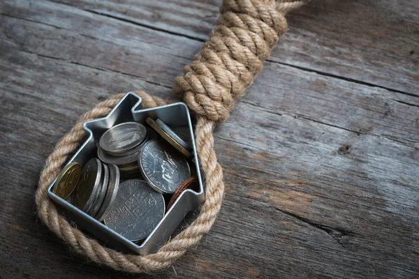 Hangman's noose ev ve kahverengi ahşap yüzey üzerinde para ile
