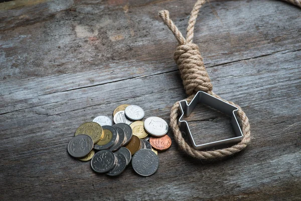 Hangman's noose ev ve kahverengi ahşap yüzey üzerinde para ile