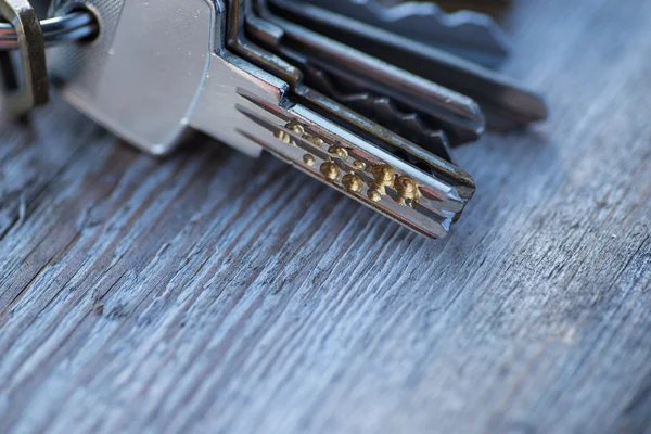 Um monte de chaves velhas desgastadas na superfície de madeira — Fotografia de Stock