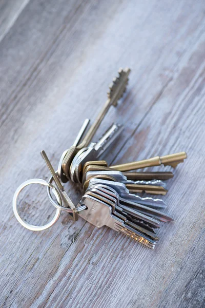 A bunch of old worn keys on the wooden surface — Stock Photo, Image