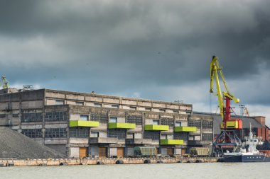 Cargo cranes and railway cars in the port under the stormy sky
