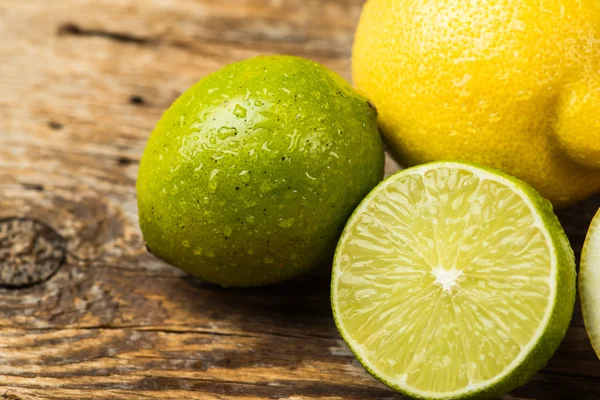 Fresh and juicy lemons and lime on a wooden surface — Stock Fotó