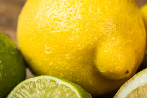 Свіжі та соковиті лимони та лайм на дерев'яній поверхні — стокове фото