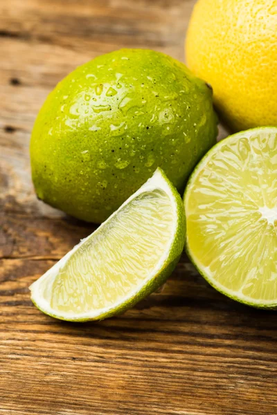 Fresh and juicy lemons and lime on a wooden surface — ストック写真