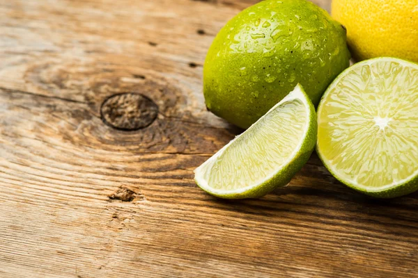 Fresh and juicy lemons and lime on a wooden surface — Stock Fotó