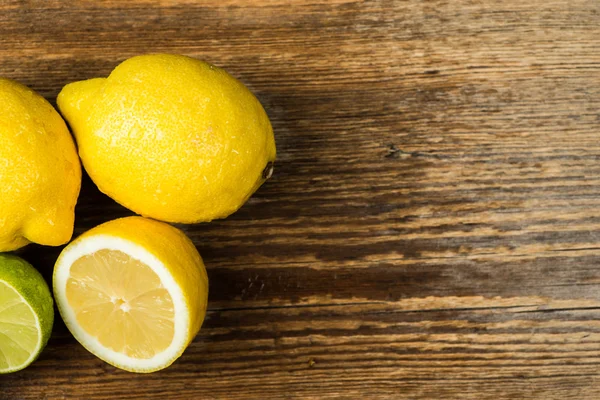 Fresh and juicy lemons and lime on a wooden surface — Stock Fotó