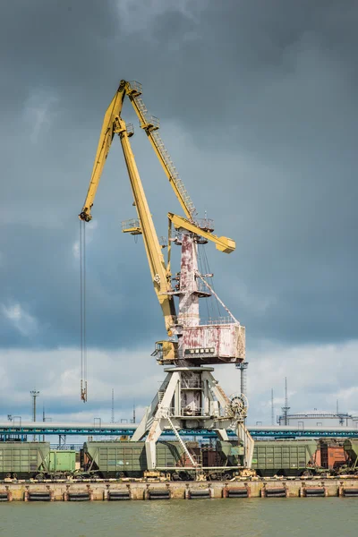 Cargo cranes and railway cars in the port under the stormy sky