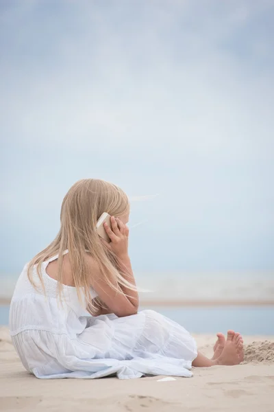 Schönes junges Mädchen telefoniert am Meer — Stockfoto