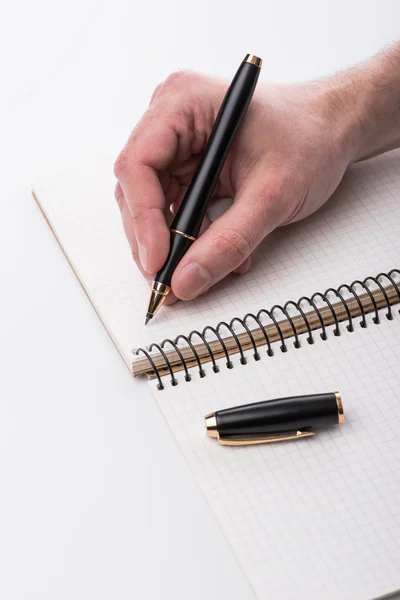 Homme écrivant une note avec un stylo à bille noir à la main, isolé — Photo