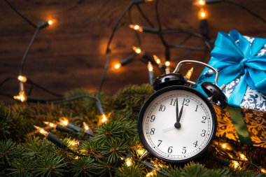 Sunni Noel ağacı, hediyeler, ışıklar ve saatin üzerine ahşap duvar