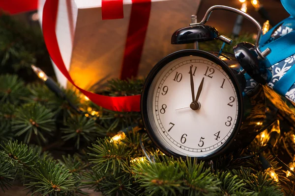 Vánoční stromečky, dary, světla a hodiny nad dřevěnou zeď — Stock fotografie