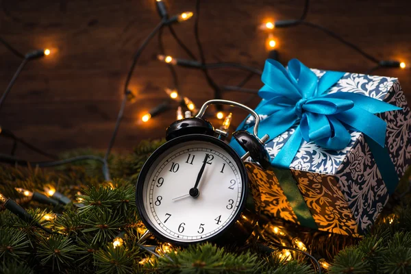 Sunni Noel ağacı, hediyeler, ışıklar ve saatin üzerine ahşap duvar