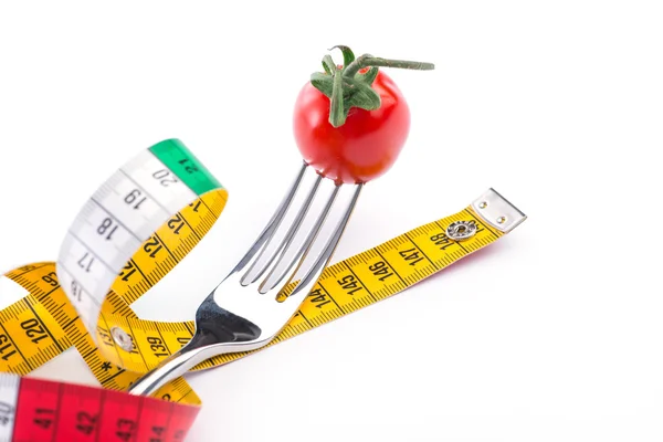 Fork,tomato and metering tape over the white background — Stock Photo, Image