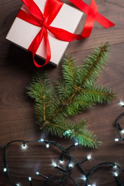 Noel hediye kutu kırmızı yay ve ahşap yüzey ışıkları ile