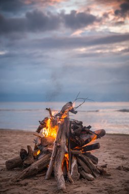 Dramatik bulutlar ile plajda şenlik ateşi
