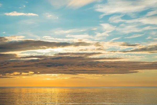 Pôr do sol de verão na praia com nuvens sobre o céu — Fotografia de Stock