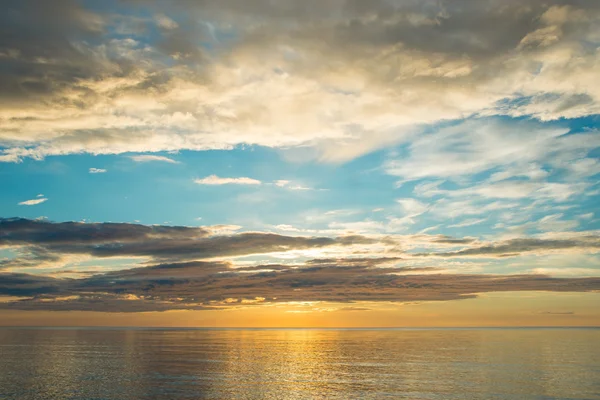 Bulutlu gökyüzü üzerinde sahilde yaz günbatımı — Stok fotoğraf