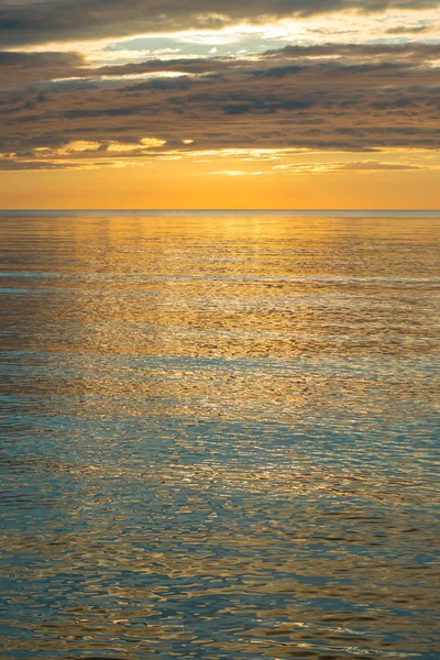 Pôr do sol de verão na praia com nuvens sobre o céu — Fotografia de Stock