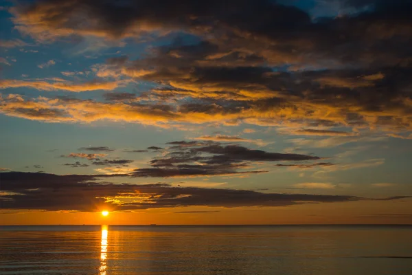 Pôr do sol de verão na praia com nuvens sobre o céu — Fotografia de Stock