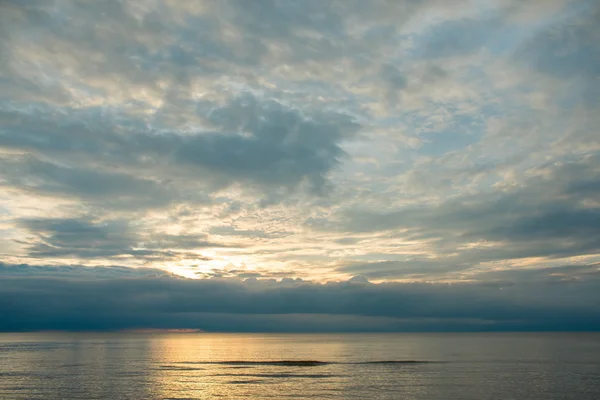 Pôr do sol de verão na praia com nuvens sobre o céu — Fotografia de Stock