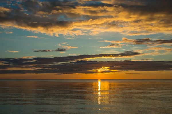 Bulutlu gökyüzü üzerinde sahilde yaz günbatımı — Stok fotoğraf