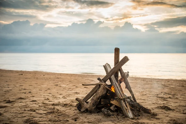 Bonfire at the beach with dramatic clouds