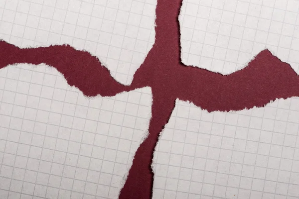 Шматочки рваного паперу на темно-червоному тлі — стокове фото
