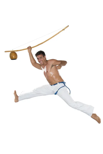 Capoeira, Homem Brasileiro pulando, segurando um Berimbau . — Fotografia de Stock