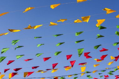 Kiraz kuşu, renkli parti bayrakları, mavi gökyüzü.