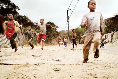 Children running in township, South Africa. clipart
